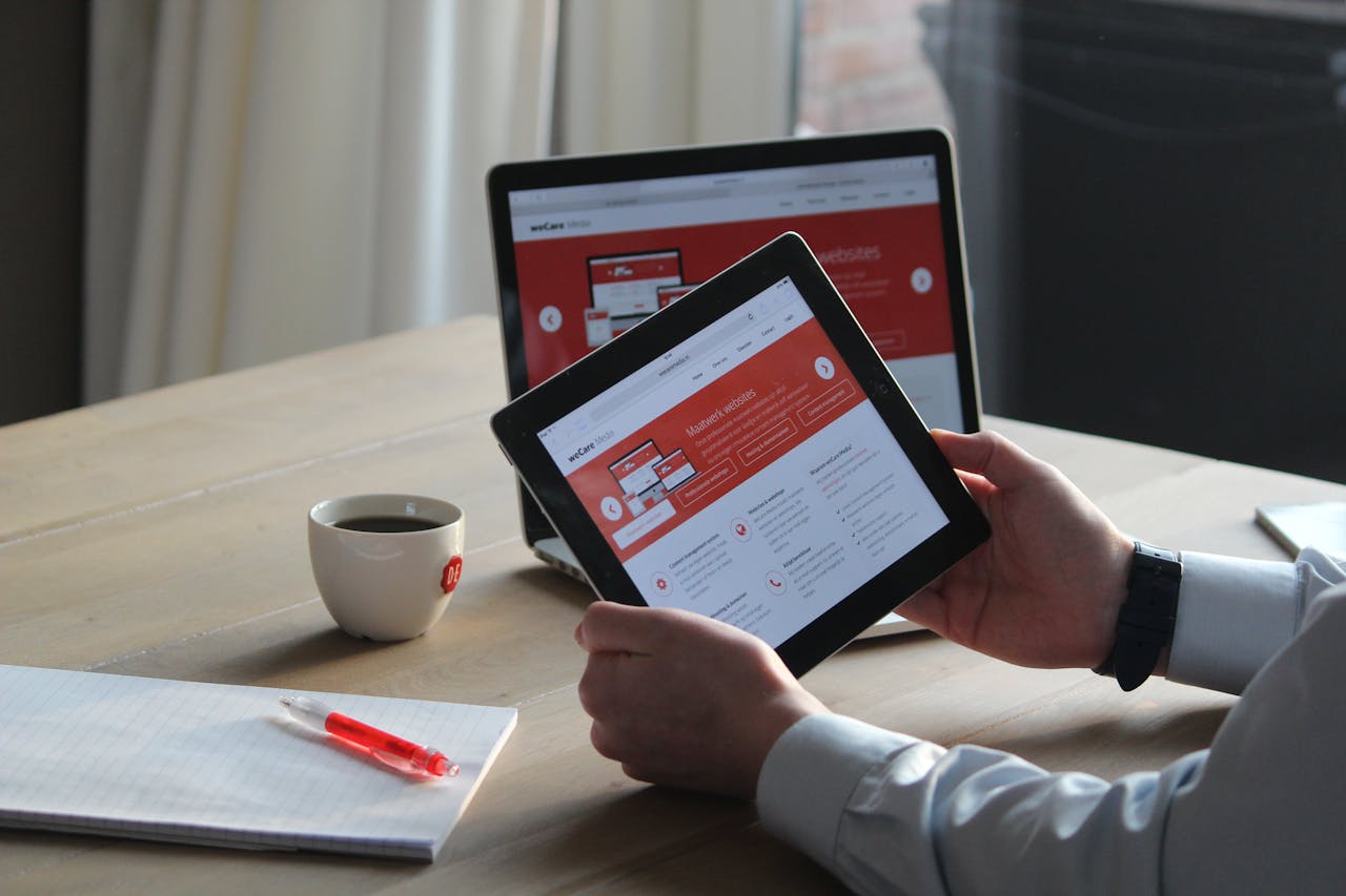 The Art of Drawing Readers In: Your attractive post title goes here Business professional using a tablet and laptop with a hot drink, focusing on digital content review.